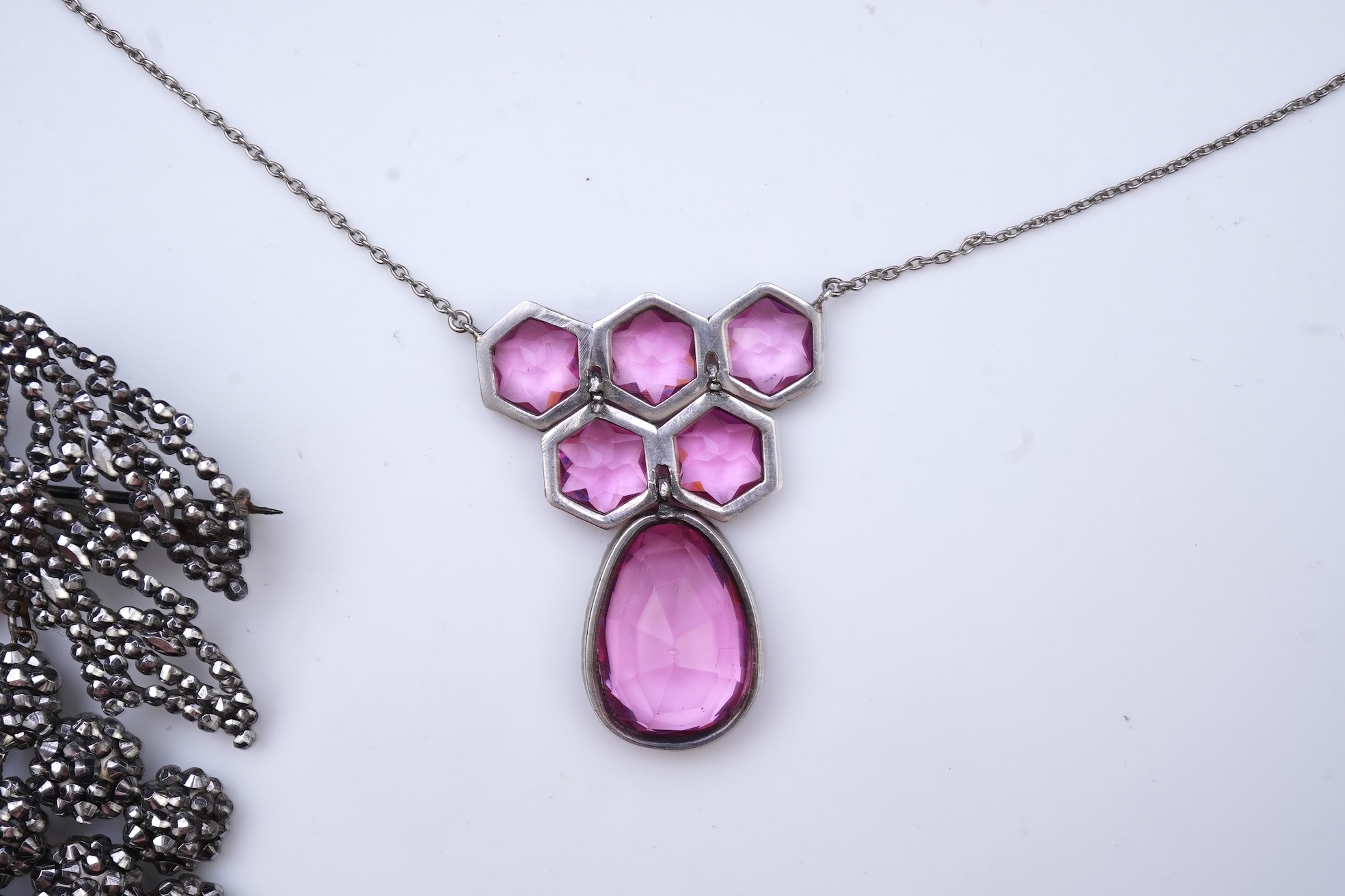 A cut steel brooch, 19th century, and a pink paste pendant